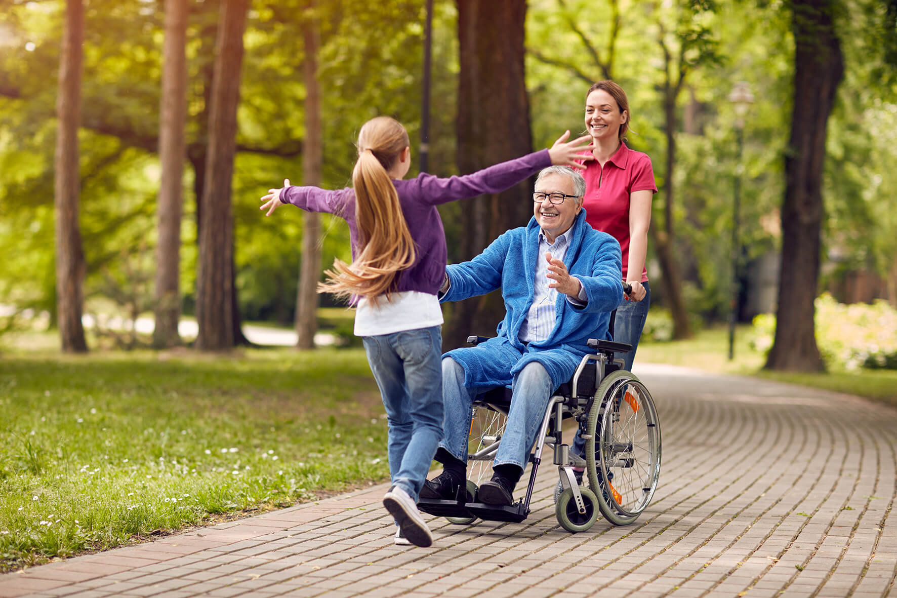 Family reunion with man in wheelchair greeting granddaughter