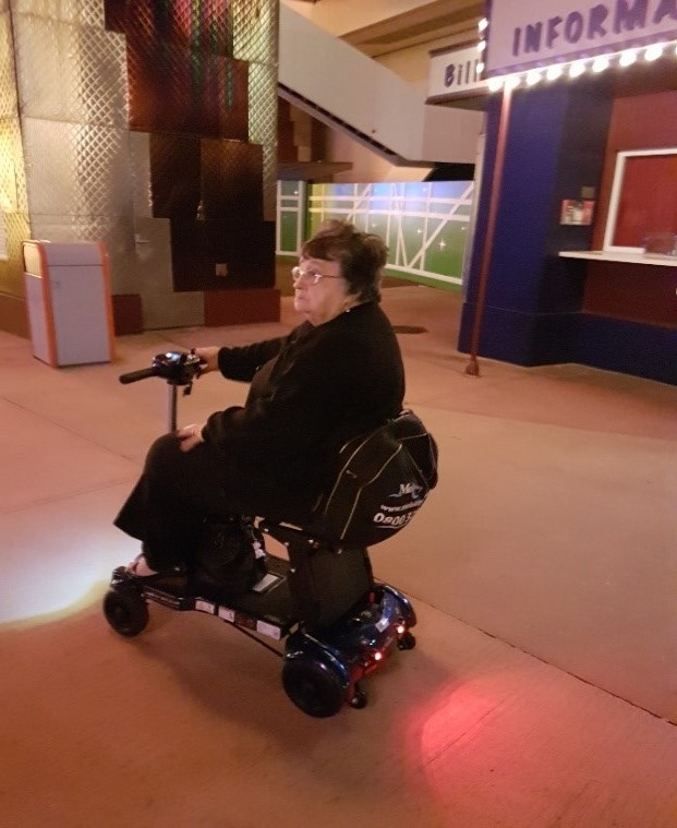 Lady riding her i3 mobility scooter around Disneyland Paris