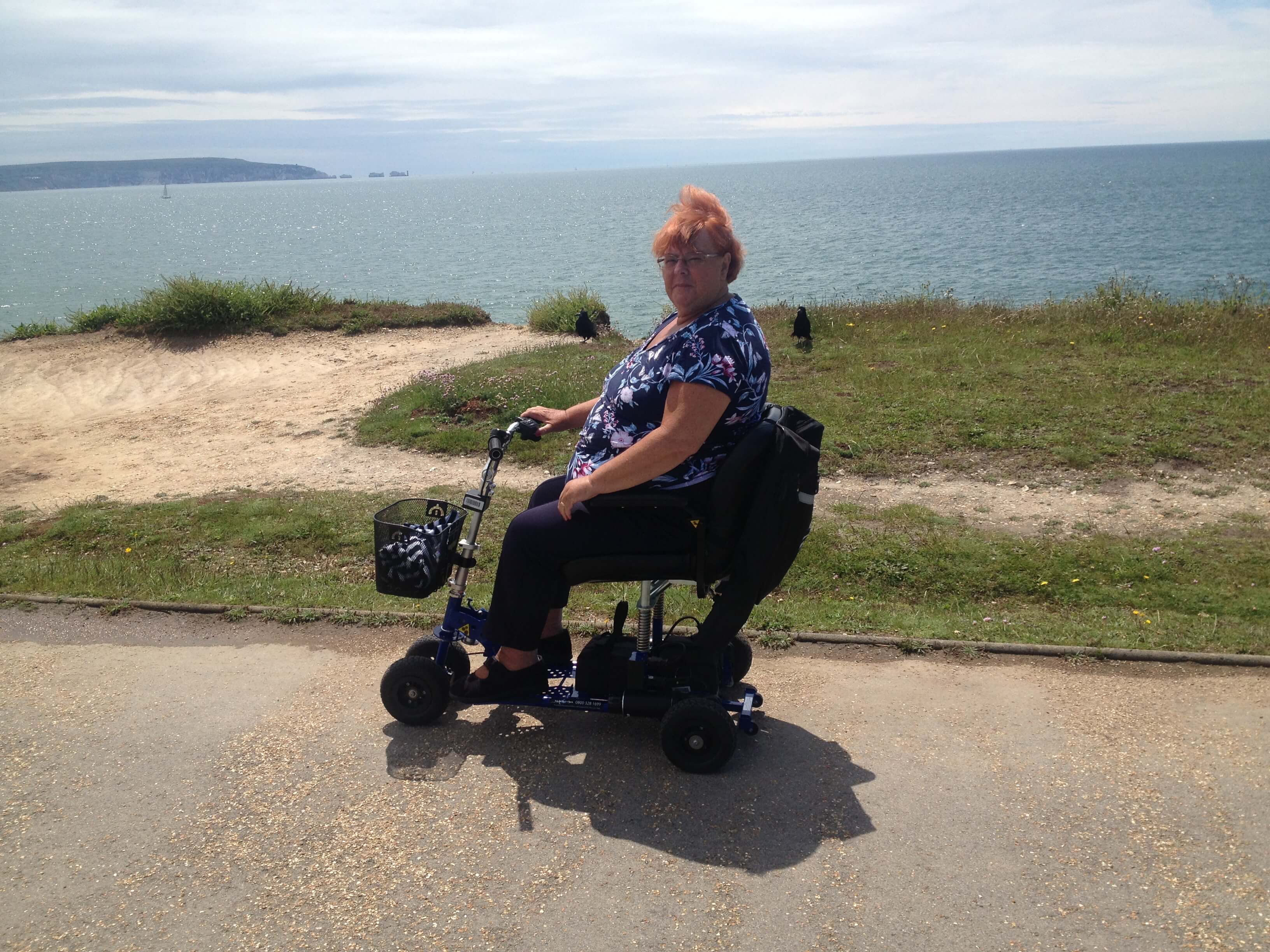 Lady on a mobility scooter overlooking the sea